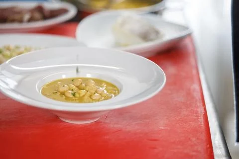 Dish of cooked white beans over a red cutting board Stock Photos