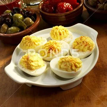 Dish of Deviled Eggs with Olives and Peppers in the Background Stock-Fotos