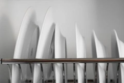 Dish drying metal rack with big nice white clean plates. Traditional comfortable Stock Photos