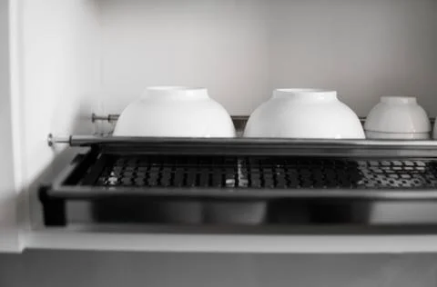 Dish drying metal rack with big nice white clean plates. Traditional comfortable Stock Photos