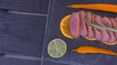 A dish of duck breasts on an orange sofa. Well-baked duck. Video stock 110026818