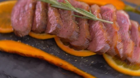 A dish of duck breasts on an orange sofa. Well-baked duck. 動画素材 110030694