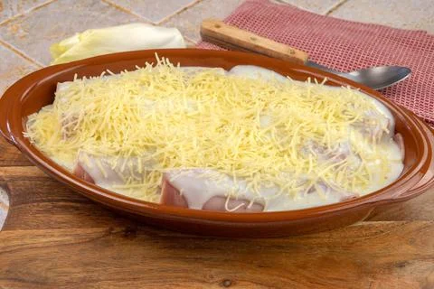 Dish of endives with ham on a table Foto stock