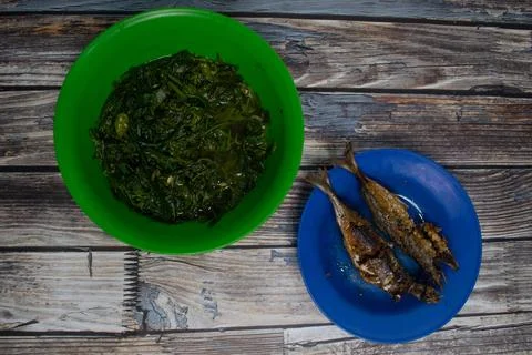 This dish features vegetables and fried fish, perfect for lunch. Stock Photos