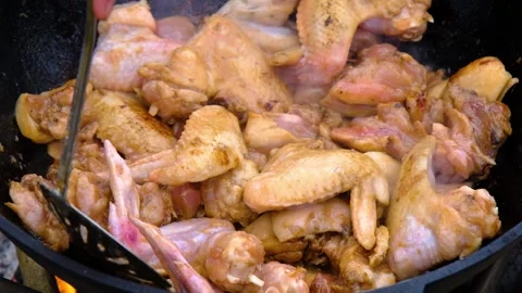 A dish on a fire in a cauldron. The meat is stewed in a cauldron. Chicken meat Stock-Footage 278463087