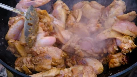 A dish on a fire in a cauldron. The meat is stewed in a cauldron. Chicken meat Stock Footage 278925971