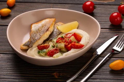 Dish with fried fish cod, stewed potatoes with dill, pickled cucumber, limon  Stock Photos