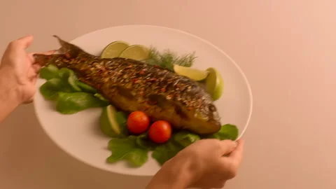 Dish of fried fish with fresh vegetables take away by the hands of a young girl Stock Footage 119494267