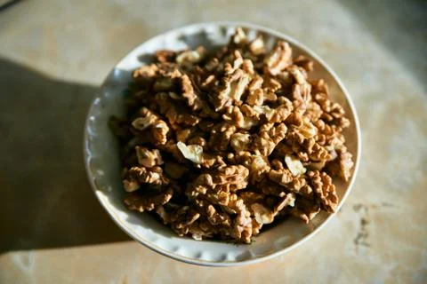 A dish full of peeled kernels of walnut closeup top view. Fotos Stock