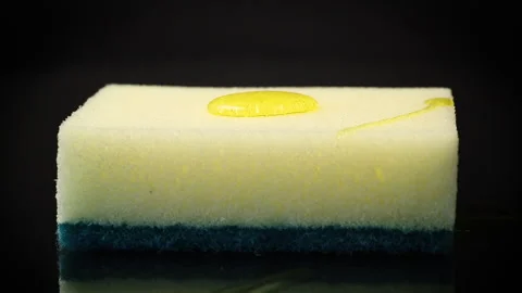 Dish gel pours onto a kitchen sponge on a black background. 스톡 동영상 263148486