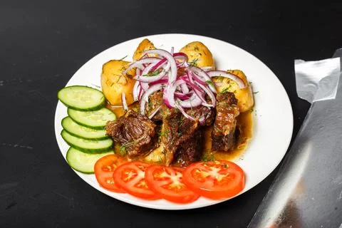 Dish Kazan-Kebab, with fried meat and vegetables, white plate, isolated Stock Photos