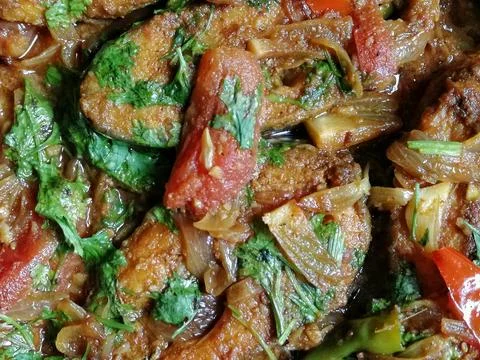 Dish made with fish pieces, mixed spices, tomato, potato, oil, coriander leaves Foto stock