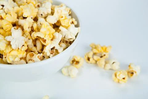 Dish with popcorn on white Stock Photos