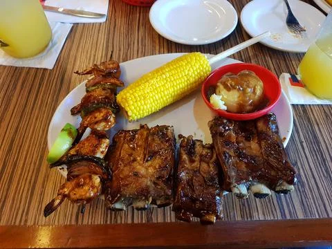 Dish of pork ribs accompanied by mashed potatoes and yellow corn Stock Photos