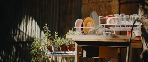 Dish rack with dishes and planters near an old vintage house, cinematic Stock Footage 124696692