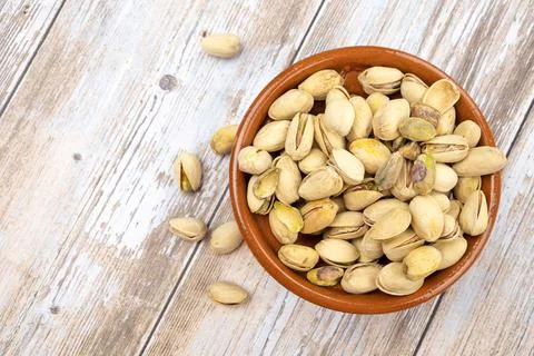 Dish of roasted pistachios on a table Stock Photos