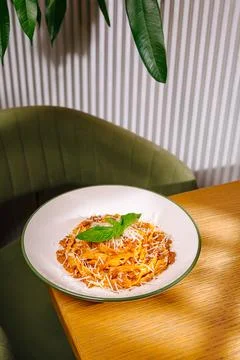 Dish served on table in restaurant with green plant in background Stock Photos