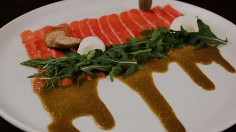 A dish of sliced red fish with sauce, herbs and bread Stock Footage 328184702