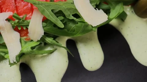 A dish of sliced red fish with sauce, herbs and bread Stockbeeldmateriaal 328186281