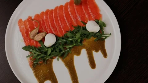 A dish of sliced red fish with sauce, herbs and bread 스톡 동영상 328187161