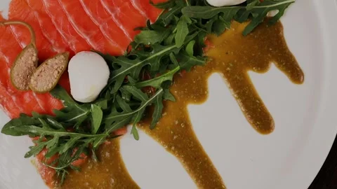 A dish of sliced red fish with sauce, herbs and bread Stock Footage 328189071