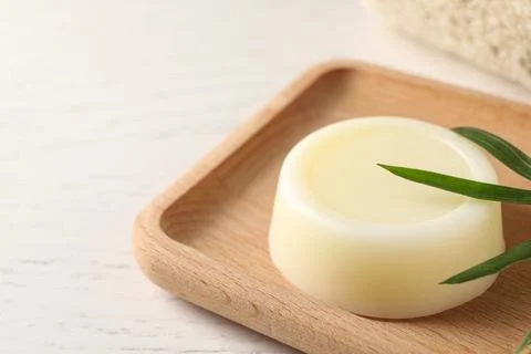 Dish with solid shampoo bar on white table, closeup. Space for text Stock Photos