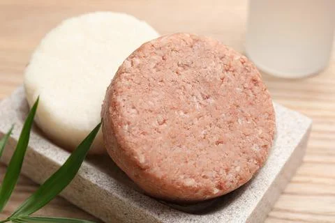 Dish with solid shampoo bars on wooden table, closeup 스톡 사진
