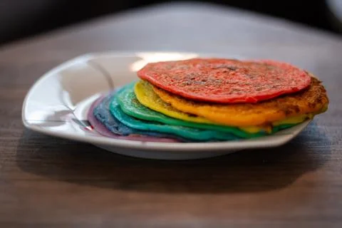Dish With A Stack Of Rainbow Coloured Pancakes Stock Photos