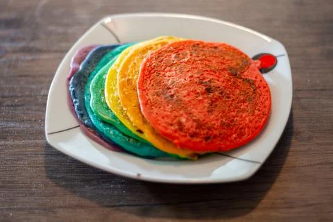 Dish With A Stack Of Rainbow Coloured Pancakes Stock Photos