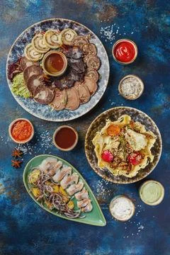 Dish with various meat cold appetizers, meat salad in cheese basket and salte Stock Photos