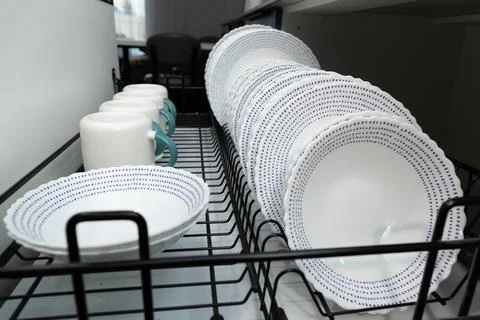 Dishes and Cups Drying on a Rack in a Cozy Kitchen Setting Stock Photos