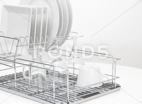 Dishes and glasses drying on metal dish rack Stock Photos