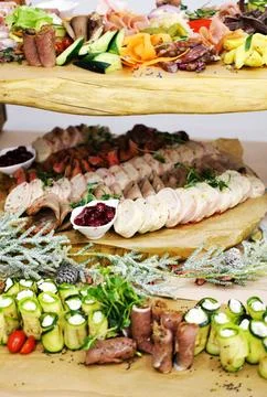 Dishes on the buffet table. Meat, vegetable and fish snacks on wooden trays. Stock Photos