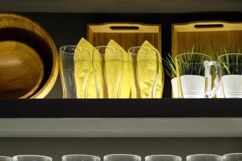 Dishes cups plates on a stand. Bottom light. Napkins. Stock Photos