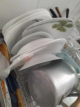 Dishes washed on the kitchen drying rack. Stock Photos
