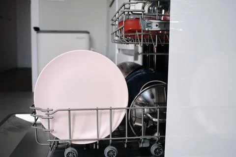 Dishwasher loading dirty dishes for cleaning process Stock Photos