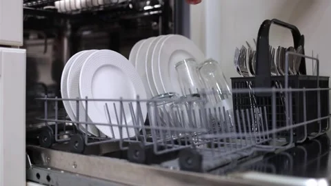 Dishwasher loading process with clean plates and glasses arranged in the rack, Video stock 324295794