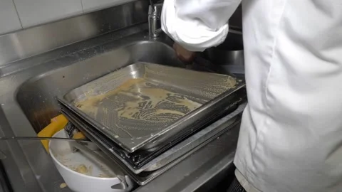 Dishwasher Scrubbing Large Baking Trays in the Restaurant Kitchen Sink 스톡 동영상 336793700