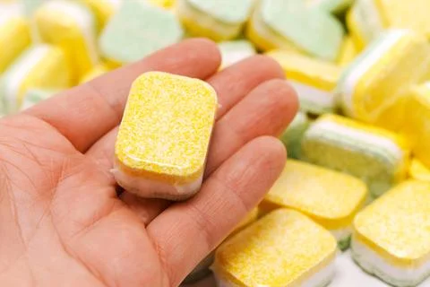 Dishwasher tablets being held in hand Stock Photos