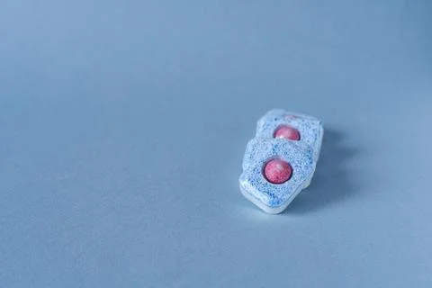 Dishwasher tablets on a blue background. Space for copying text. Stock Photos