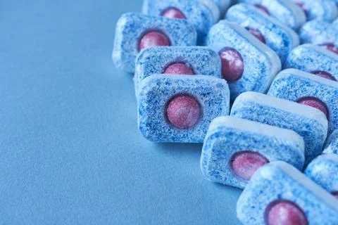 Dishwasher tablets on a light blue background. Copy space. Stock Photos