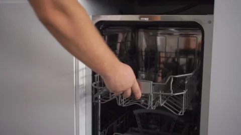 Dishwasher on white modern kitchen. Man close the door. No dishes in cupboard. Stock Footage 110905489