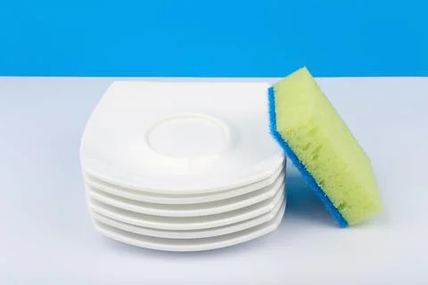 Dishwashing concept, high angle view of cleaning sponge and pile of clean Stock Photos