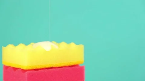 Dishwashing liquid pours onto the rotating kitchen sponges and flows from them. Stock Footage 223609877