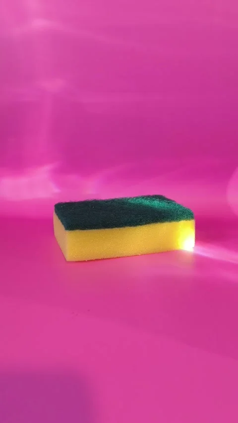 Dishwashing sponge on a bright pink background with light ripples. Stock Footage 332723291