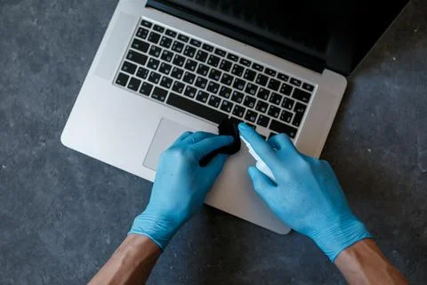 Disinfected your computer from covid-19 viruses. spray the antiseptic on your Stock Photos
