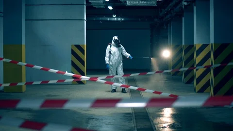 Disinfector is sanitizing empty parking unit. Coronavirus, Disinfection concept. Stock Footage 127845982