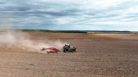 Disk harrow on plowing field. Soil cultivation field use tractor. 動画素材 211889802