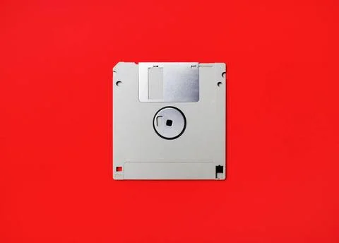 Diskette on red Gray diskette on red paper background. Floppy disc. Flat l... Stock Photos