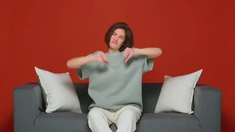 Dislike, negative feedback. Dissatisfied young girl showing thumbs down Video stock 208395089